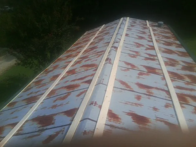 Rusted metal roof panels with new wood purlins before replacement — Storm Damage Roof Repair in Empire by Roofing Brothers